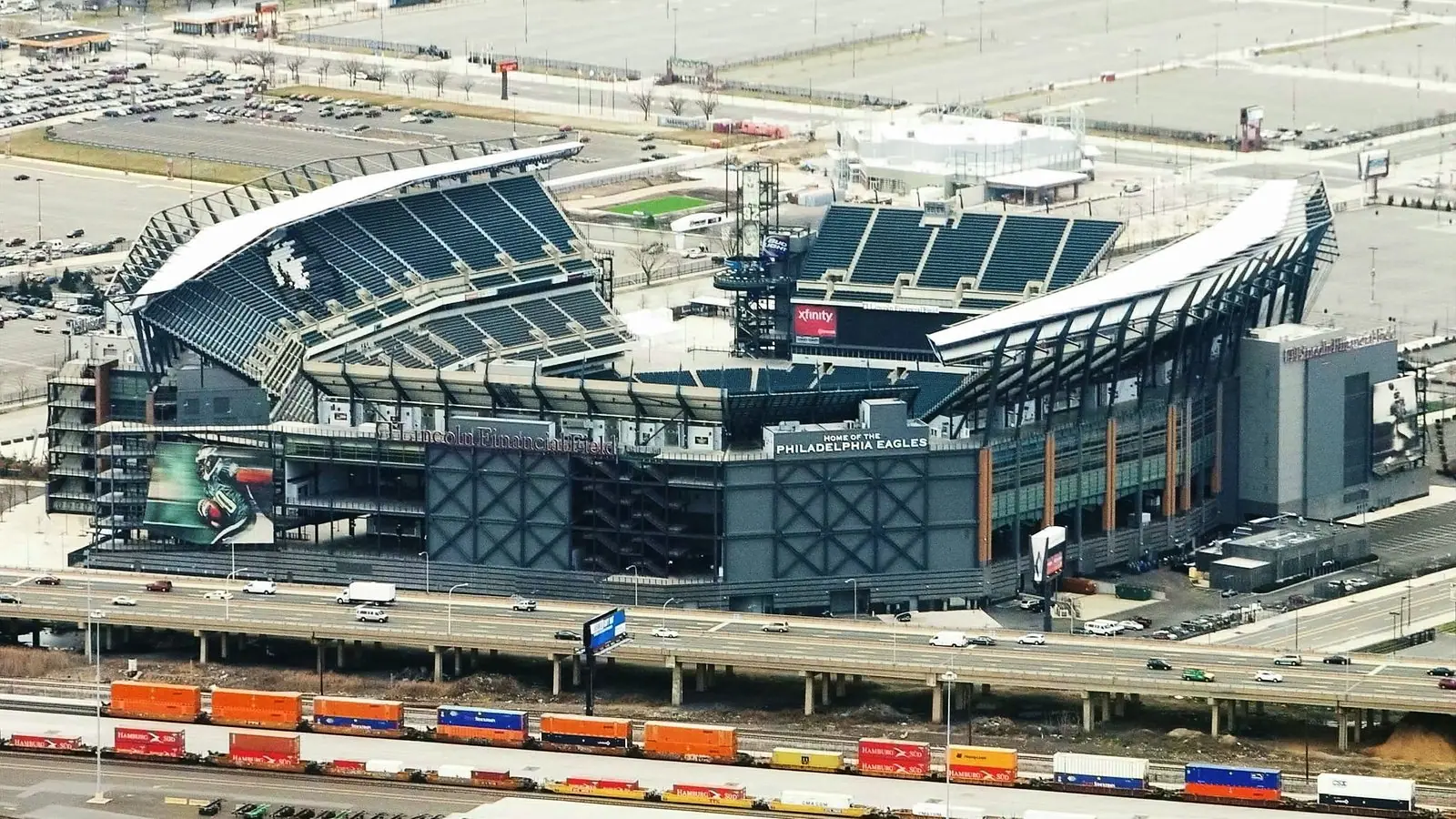 Aerial view of Lincoln Financial Field in Philadelphia, home of the Eagles, with an elevated highway and freight train in the foreground