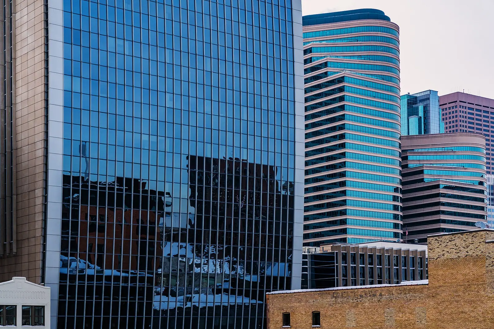 Glass facade of the federal courthouse in downtown Minneapolis with office towers behind it