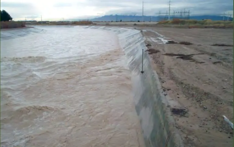 Muddy floodwater rushes through the Las Vegas Wash beneath Vegas Valley Drive after a desert storm